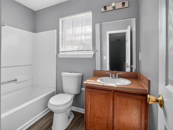 A bathroom with a toilet, sink, and bathtub.