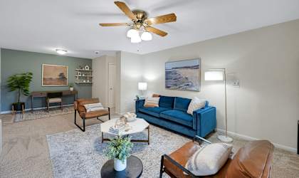 a living room with a ceiling fan and a blue couch