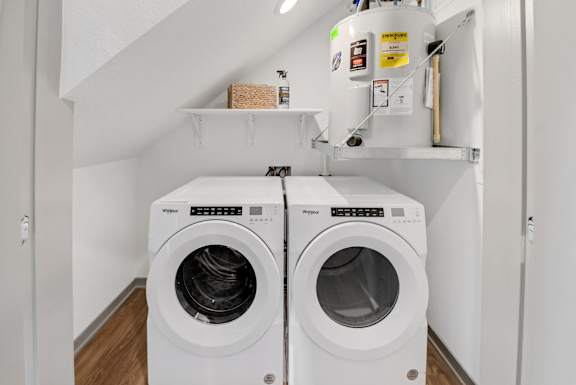 a washer and dryer in a laundry room with white walls and wooden floorsat The BLVD at Wilson Crossings, Wyoming, MI