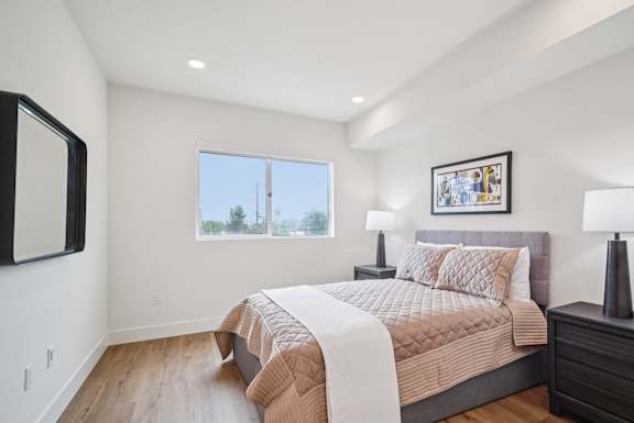 A bedroom with a large bed and a window overlooking the trees.