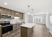 Thumbnail 21 of 22 - A modern kitchen with wooden cabinets and stainless steel appliances.