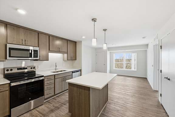A modern kitchen with wooden cabinets and stainless steel appliances.