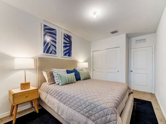 a bedroom with a large bed and two windows
