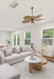A living room with a grey sofa, wooden coffee table, and a ceiling fan.
