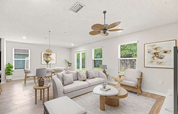 A living room with a grey sofa, wooden coffee table, and a ceiling fan.