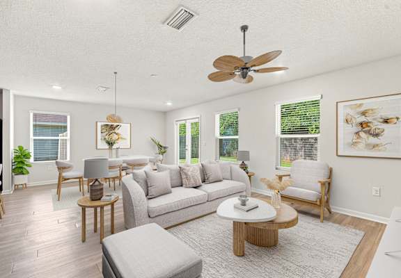 A living room with a grey sofa, wooden coffee table, and a ceiling fan.