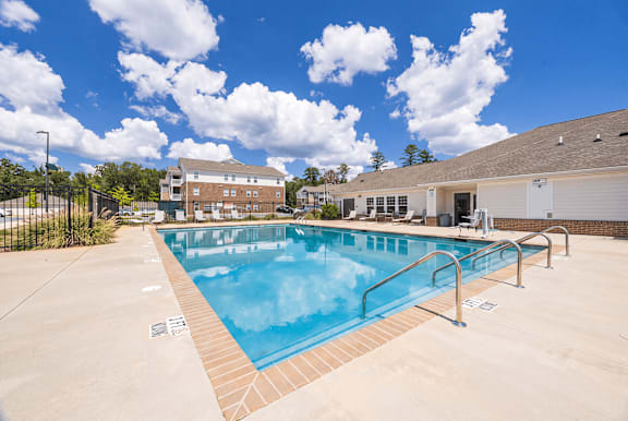 A large outdoor swimming pool with a metal railing.