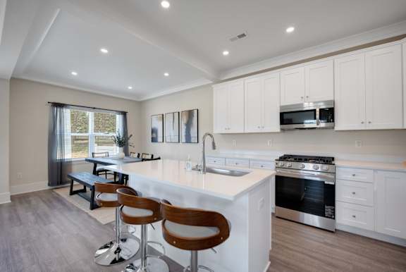 A modern kitchen with white cabinets and stainless steel appliances.