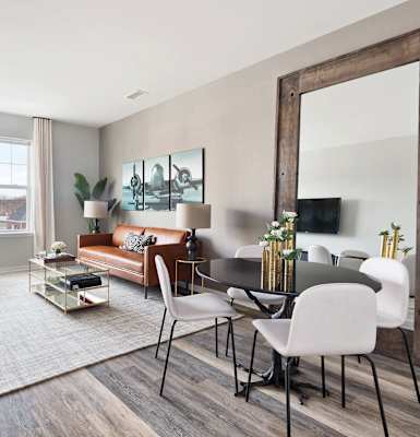 A modern living room with a large mirror and a grey sofa. at Hillside Club Apartments, Livingston, NJ, 07039