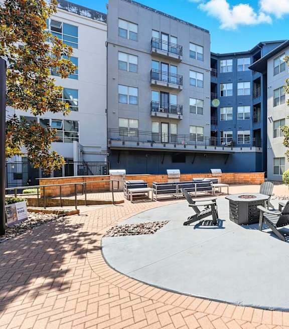 A courtyard with a table and chairs surrounded by apartment buildings.