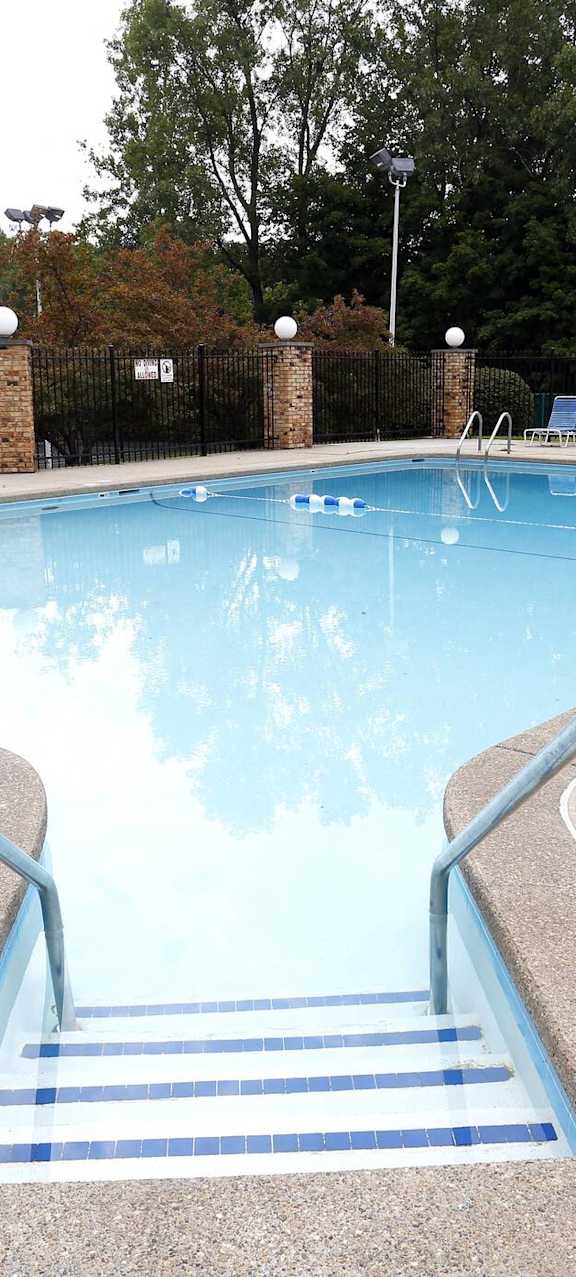 A pool with a metal staircase leading down to it.