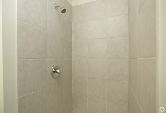 Walk in shower with a single dial temperature handle gray stone