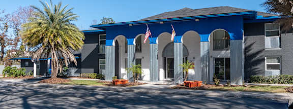 A building with a blue roof and a flag on it at Mandarin Bay Apartments in Jacksonville, FL.