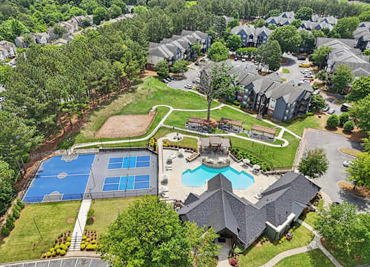 A bird's eye view of a residential area with a swimming pool and tennis court.