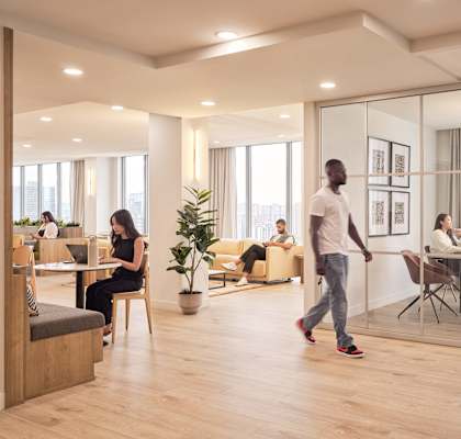 A man is walking in a modern office space.