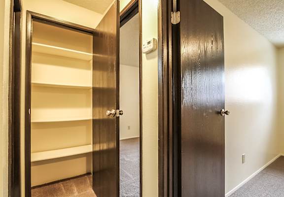 A hallway with a black door on the right and a white door on the left.