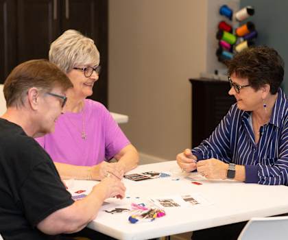 a group of people sitting at a table playing cards