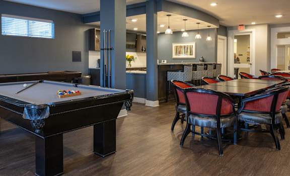 redesigned game room with billiard tables and chairs and a bar
