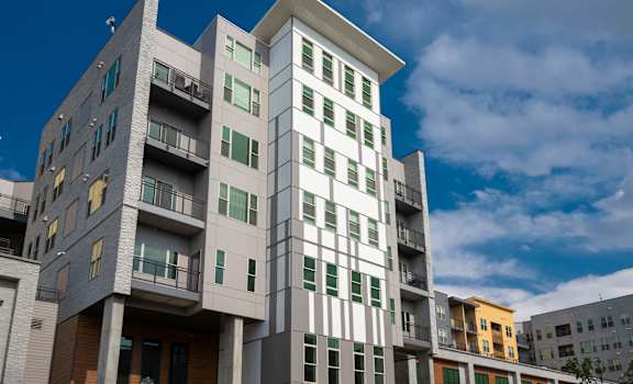 A modern apartment building with balconies and multiple floors.