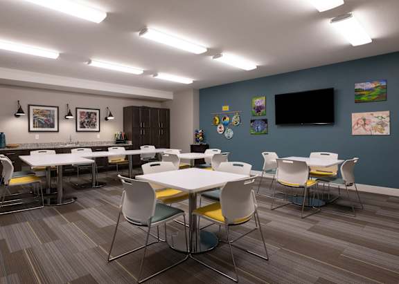 a dining room with tables and chairs and a tv