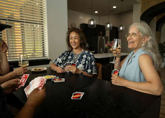 A group of people playing a card game at a table.