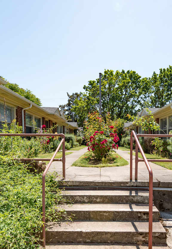 A row of houses with a red metal railing in front of them.