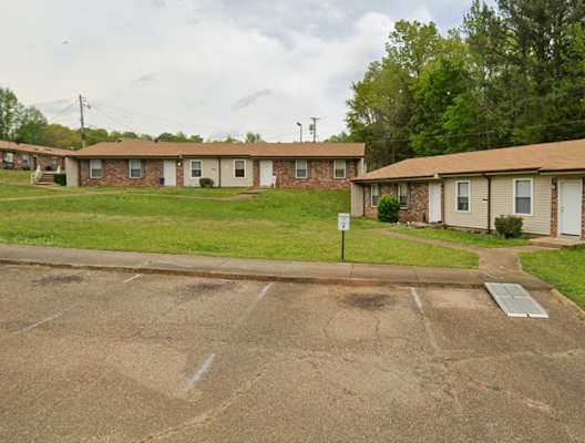 A parking lot in front of a row of houses.