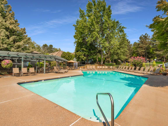 King's Court apartments swimming pool with chaise lounge chairs and trees in the background at King's Court Apartments, Oregon, 97006