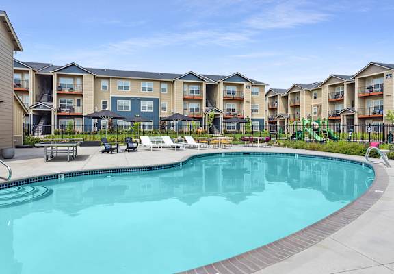 a swimming pool with an apartment building in the background