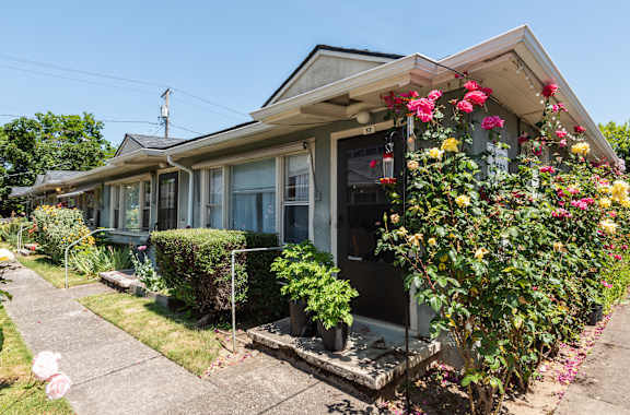 A house with a grey roof and a flower box on the front.
