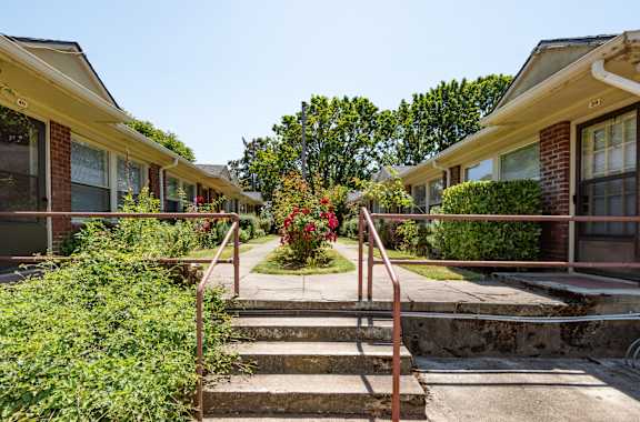 A row of houses with a red metal railing in front of them.