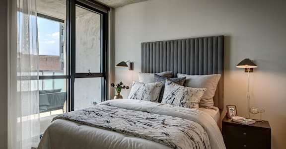 A bedroom with a large bed and a window with curtains. at The Mason Apartments, Illinois, 60607