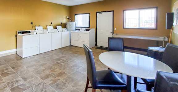 A kitchen with a table and chairs.