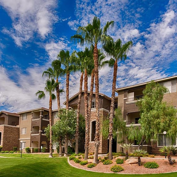 an apartment building with palm trees in front of it