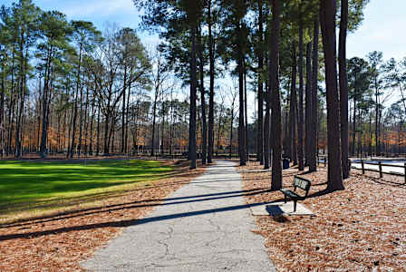 A park with a bench and a walking path.at Patriot Point Apartment Homes, Spring Lake, NC