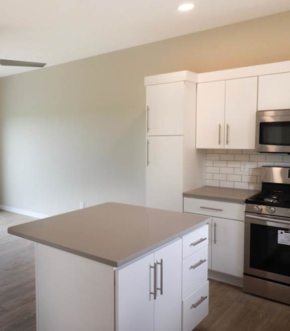 A kitchen with white cabinets and a large island.
