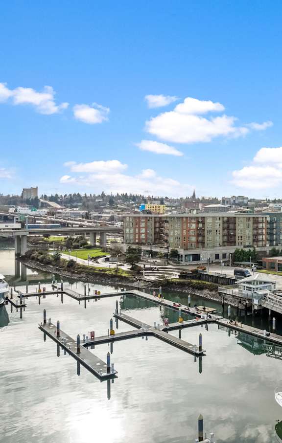A cityscape with a boat docked at a pier.
