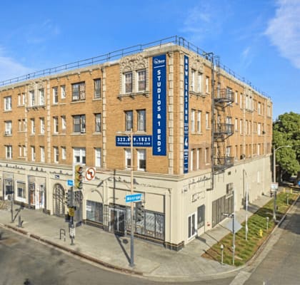 A street view of a building with a blue sign that reads "The Old Standard".