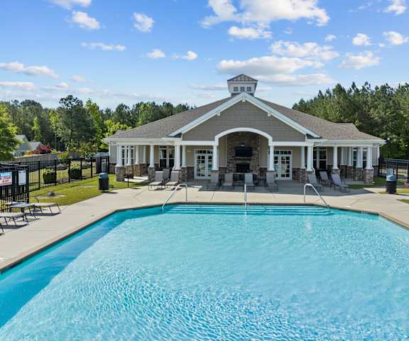 A pool in front of a building with a fence around it.