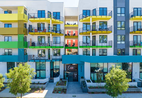 A modern apartment complex with balconies and trees.
