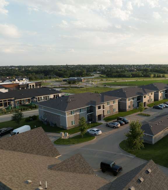 A large building complex with a parking lot in front.