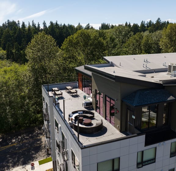 an aerial view of a group of apartment buildings with trees in the background
