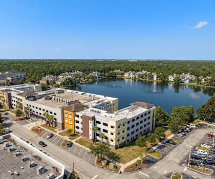 an aerial view of a building next to a lake