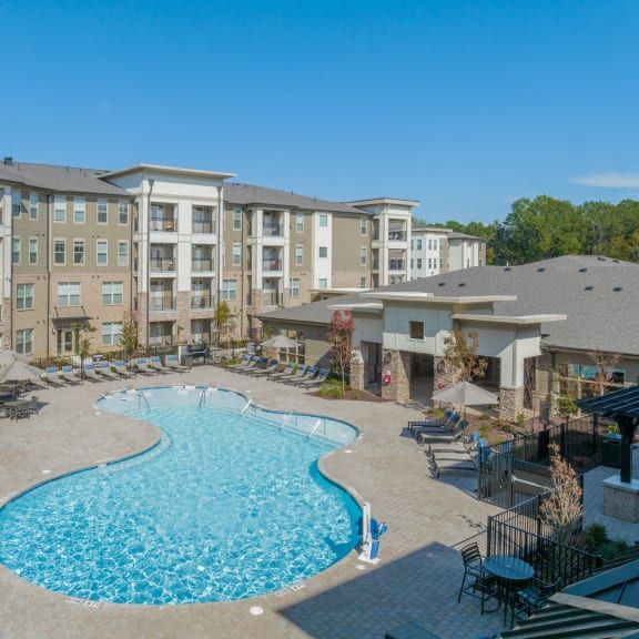 a swimming pool with an apartment building in the background