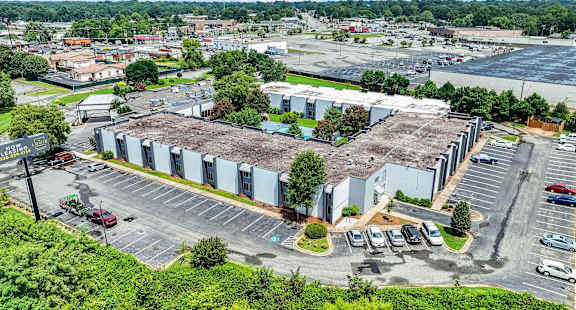 A large industrial building with a parking lot in front.