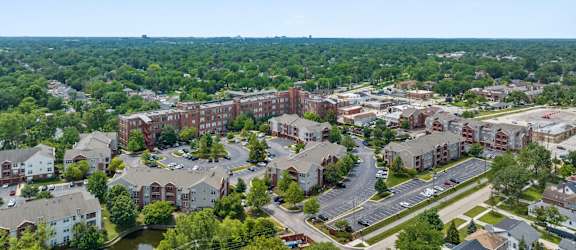 A view of a residential area with apartment buildings and a parking lot.