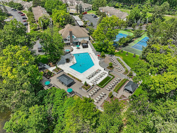 A bird's eye view of a resort with a swimming pool and tennis court.