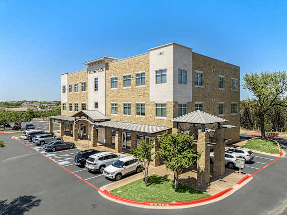 A parking lot in front of a building with a sign that reads "PALMER".