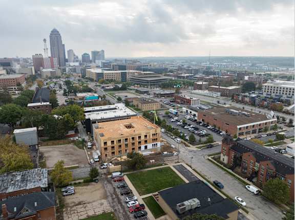 A cityscape with a large building in the foreground and a skyline in the background.