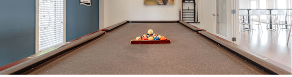 A room with a pool table and a painting on the wall.